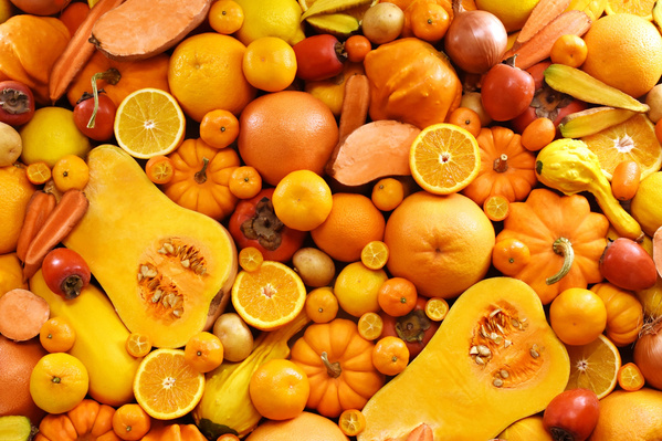 KI generiert: Verschiedene gelbe und orangefarbene Früchte und Gemüsesorten in einer dichten Anordnung.