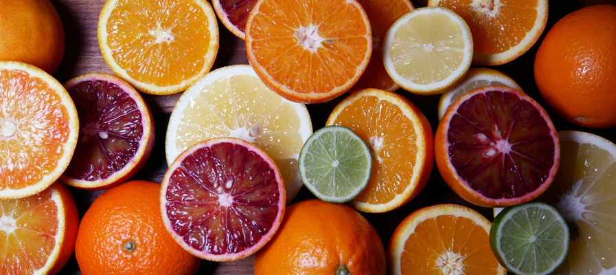 KI generiert: Das Bild zeigt eine Vielzahl von aufgeschnittenen Zitrusfrüchten, darunter Orangen, Blutorangen, Zitronen und Limetten, die sowohl in ganzer Form als auch als Hälften präsent sind. Die Farben der Früchte sorgen für ein lebhaftes und frisches Erscheinungsbild.