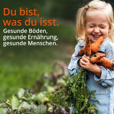 KI generiert: Ein Kind hält Karotten im Garten.  
Text: "Du bist, was du isst. Gesunde Böden, gesunde Ernährung, gesunde Menschen."