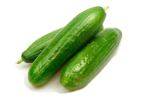 KI generiert: Drei grüne Gurken liegen nebeneinander auf weißem Hintergrund.