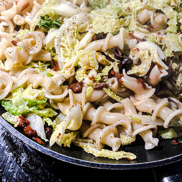 KI-generierte Beschreibung: Hauptinhalt des Bildes: Ofenfrische Pizza mit Salat.