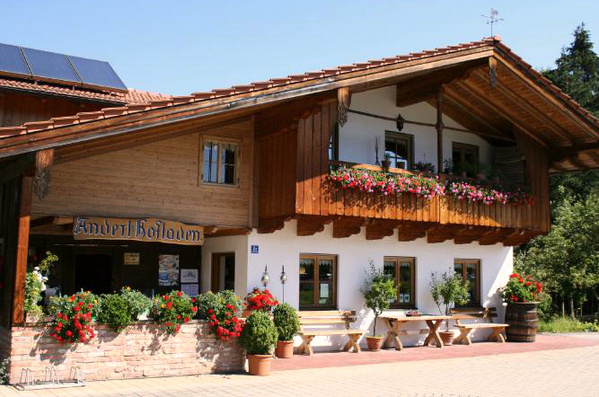 KI generiert: Ein traditionelles Haus mit Holzverkleidung; "Anderlbauer" steht über dem Eingang.