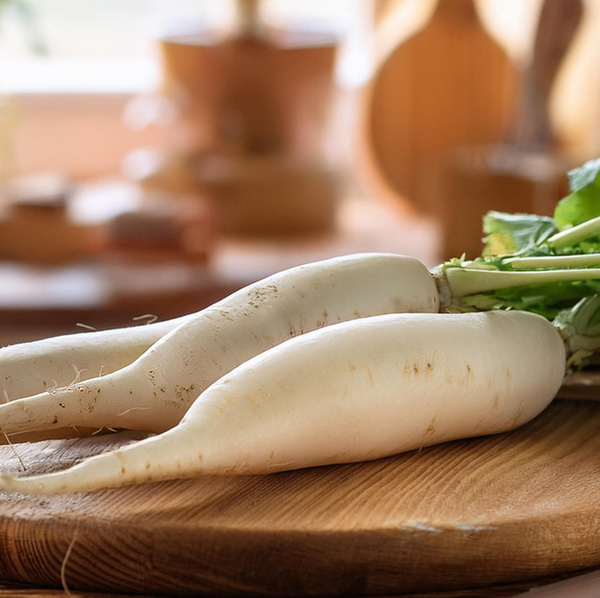 Zwei weiße Rettiche liegen auf einem Holztisch 