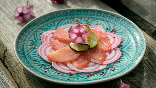 KI generiert: Das Bild zeigt eine aufgeschnittene Gemüsetarte mit roten und violetten Schichten, garniert mit Pilzen und Kräutern. Sie befindet sich auf einem runden Teller auf einem rustikalen Holztisch.