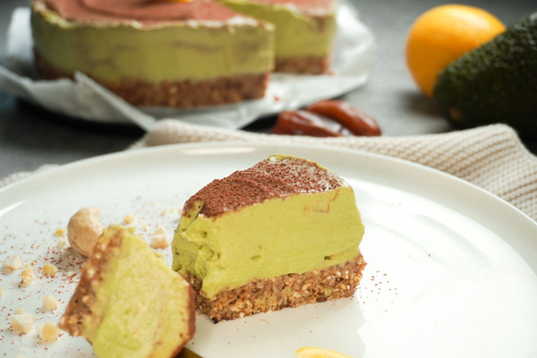 KI generiert: Das Bild zeigt ein Gericht mit cremigem Brei, garniert mit buntem, geröstetem Gemüse und Mandelsplittern. Daneben sind frische Karotten in einem Korb sichtbar.