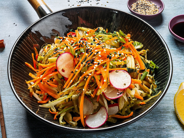 KI generiert: Eine Schüssel mit geschnittenem Gemüse, darunter Karotten und Radieschen, garniert mit Sesam.