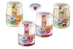 KI generiert: Vier Gläser Bio-Joghurt in verschiedenen Geschmacksrichtungen. Text: "bio yogurt da latte fieno".