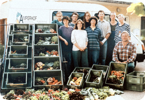 KI generiert: Gruppe vor Lieferwagen mit Gemüse in Kisten. Text: "AMPERHOF".