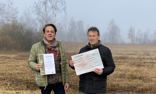 Geschäftsführer Ulrich Vogt-Bergener übergibt den Spendenscheck für das Moorprojekt Fußbergmoos.