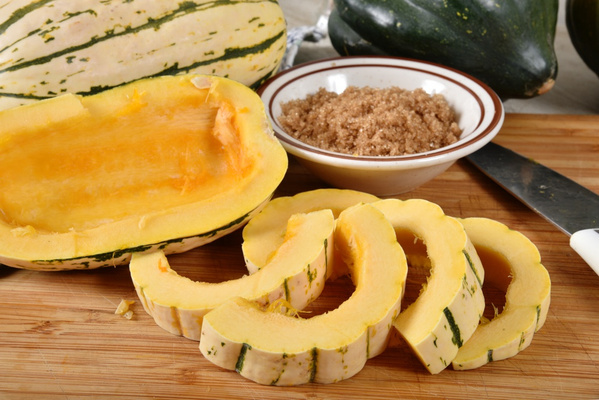 Delicata Kürbis halbiert und in Scheiben geschnitten